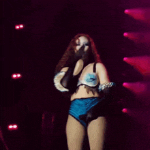 a woman is dancing on a stage in front of a pink light