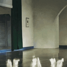 a room with a green curtain and a white wall