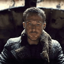 a man with a beard wearing a leather jacket with a fur collar .