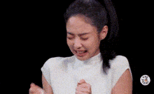 a woman in a white shirt is making a funny face and making a funny face .