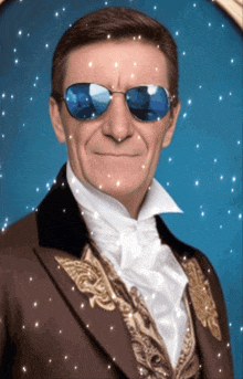 a man wearing a suit and sunglasses is smiling