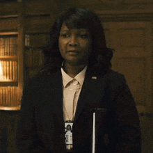 a woman in a suit has a badge that says ' secretary of state '