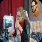 a man is drinking from a bottle while sitting in front of a computer .