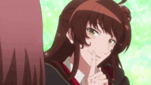 a girl with brown hair is holding her finger to her mouth