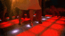 a group of people are dancing on a dance floor in a nightclub .