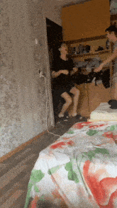a man and a woman are dancing in a room with a floral table cloth