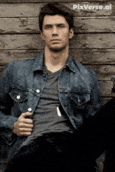 a man in a denim jacket is leaning against a wooden wall with pixverse.ai in the corner
