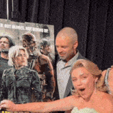 a group of people standing in front of a movie poster that says " not heroes not giving up "