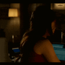 a woman sitting in front of a computer screen that says ' i 'm sorry '