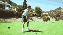 a man swings a golf club at a golf ball