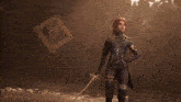 a man with red hair is holding a sword with the letter c on the handle