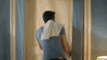a man with a towel around his neck is standing in front of a mirror