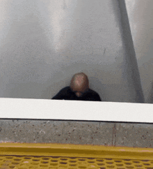 a man 's head is visible in a reflection in a glass wall