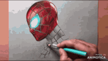 a person is drawing a spider man head with a blue pencil