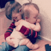 a boy is holding a baby in his arms while the baby is crying .