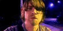 a man with a beard is taking a picture of himself on a stage .