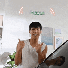 a man is giving a thumbs up in front of a sign that says ' a '