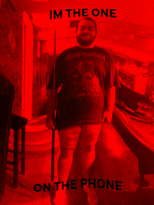 a man in an iron maiden shirt is standing in a pool hall