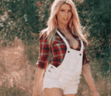 a woman wearing overalls and a plaid shirt