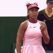 a woman wearing a pink dress and a pink nike visor