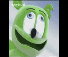 a close up of a green gummy bear with blue eyes .