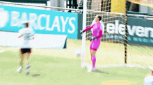 a soccer game is being played in front of a barclays ad