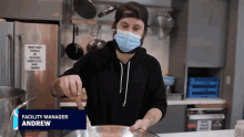 a man wearing a face mask is cooking in a kitchen with the name andrew on the bottom