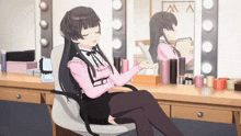 a girl in a pink shirt is sitting in front of a mirror
