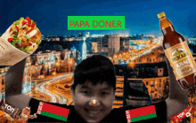 a boy holds up a bottle of papa doner in front of a city