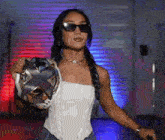 a woman wearing sunglasses is holding a trophy .