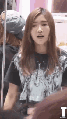 a girl wearing a shirt with a picture of a unicorn