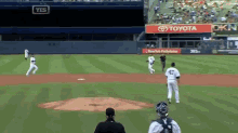 a baseball game is being played in front of a large toyota sign