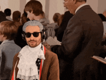 a man wearing sunglasses and a wig is standing in a crowd