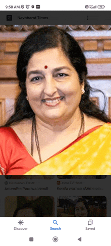 a woman in a yellow and red saree is smiling on a navbharat times app
