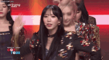 a group of girls are performing on stage with the words arirang korea on the bottom