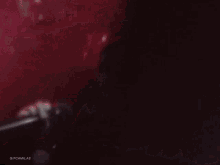 a close up of a woman singing into a microphone with the words gifcamilas on the bottom