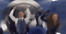 a group of people are standing in a room with their hands up .