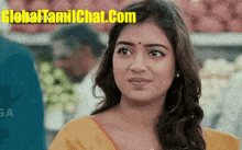 a woman is standing in front of a sign that says global tamil chat