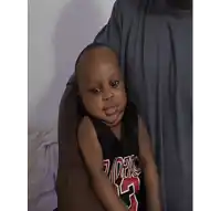 a man is holding a baby wearing a chicago bulls jersey