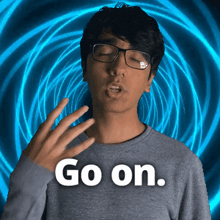 a man with glasses says go on in front of a blue swirl