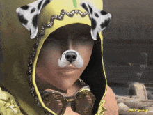 a woman wearing a yellow hood with a dalmatian mask on her face