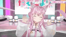 a girl with pink hair and cat ears is smiling in a video game .