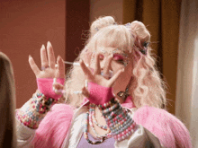 a woman with pink hair and pink gloves is making a face