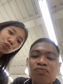 a man and a woman are posing for a picture and the woman is making a funny face