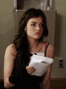 a woman is holding a piece of paper in her hand
