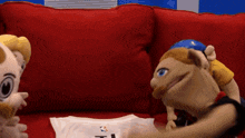 two stuffed animals are sitting on a red couch next to a white shirt that says nba