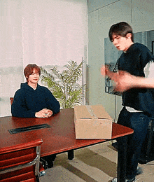 a man sitting at a desk with a box on it