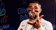 a man wearing a citizen bank jersey is making a funny face