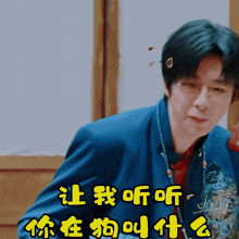a man wearing glasses and a blue jacket has chinese writing on his chest