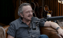a man is sitting in front of a microphone with a can of budweiser in front of him